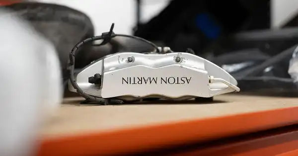 Pinza freno originale Aston Martin color argento su uno scaffale nel magazzino Eurospares.